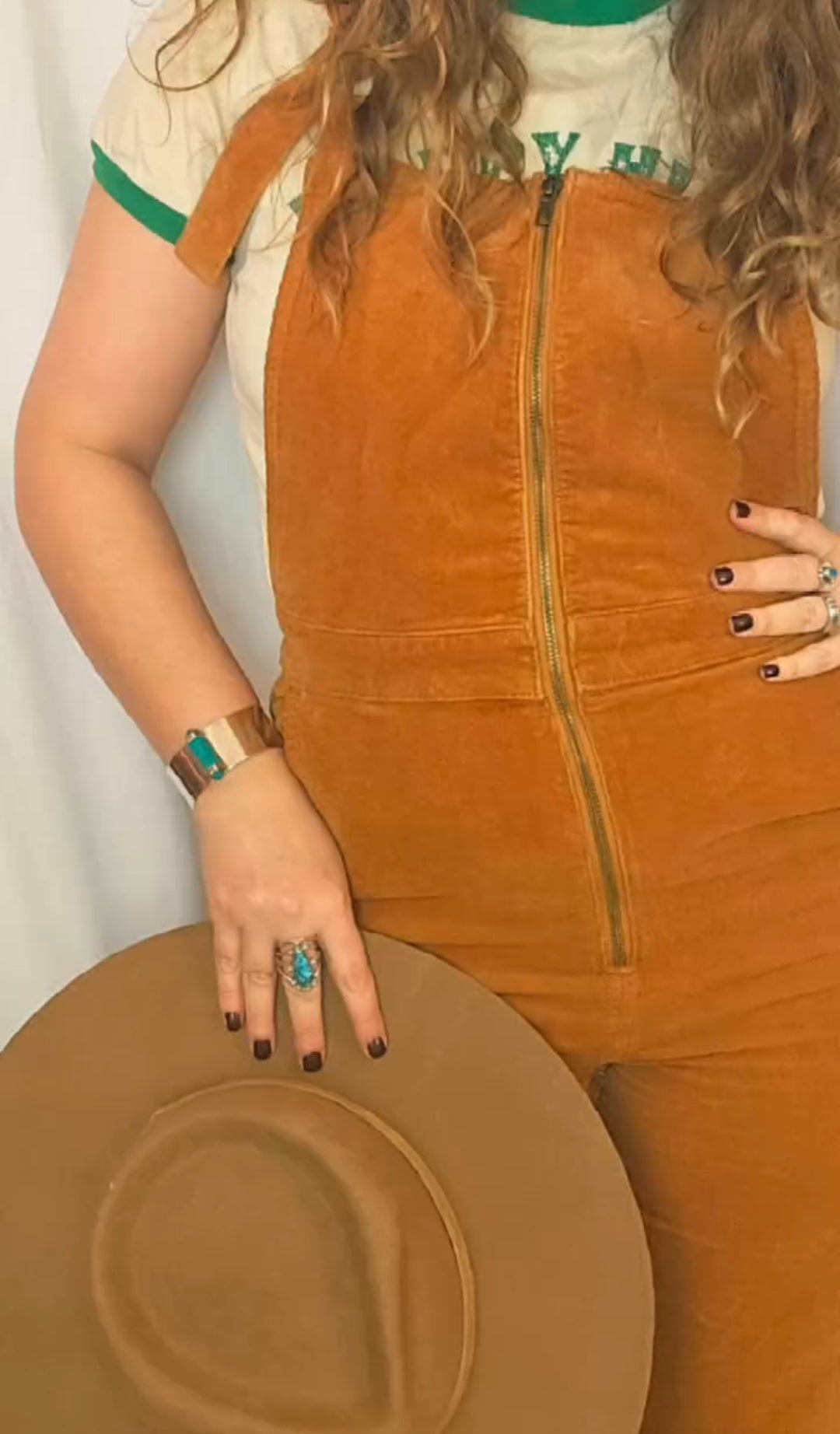 Person wearing a brown suede jacket with a plain background