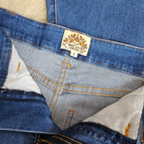 Close-up of a denim jacket with a brand label on a neutral background