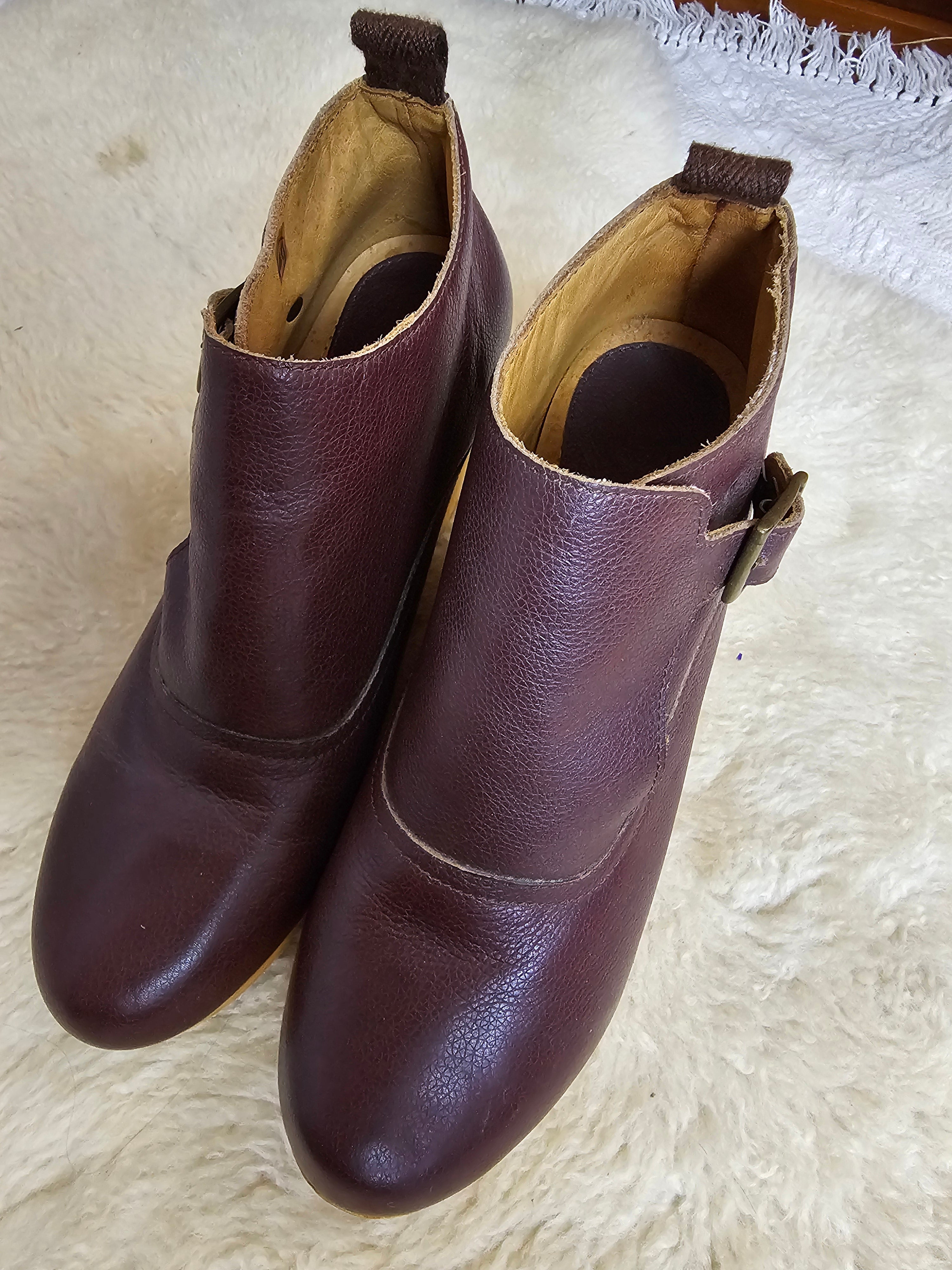 Pair of brown leather shoes on a white textured surface