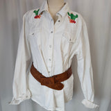 White shirt with floral embroidery on a mannequin against a plain background