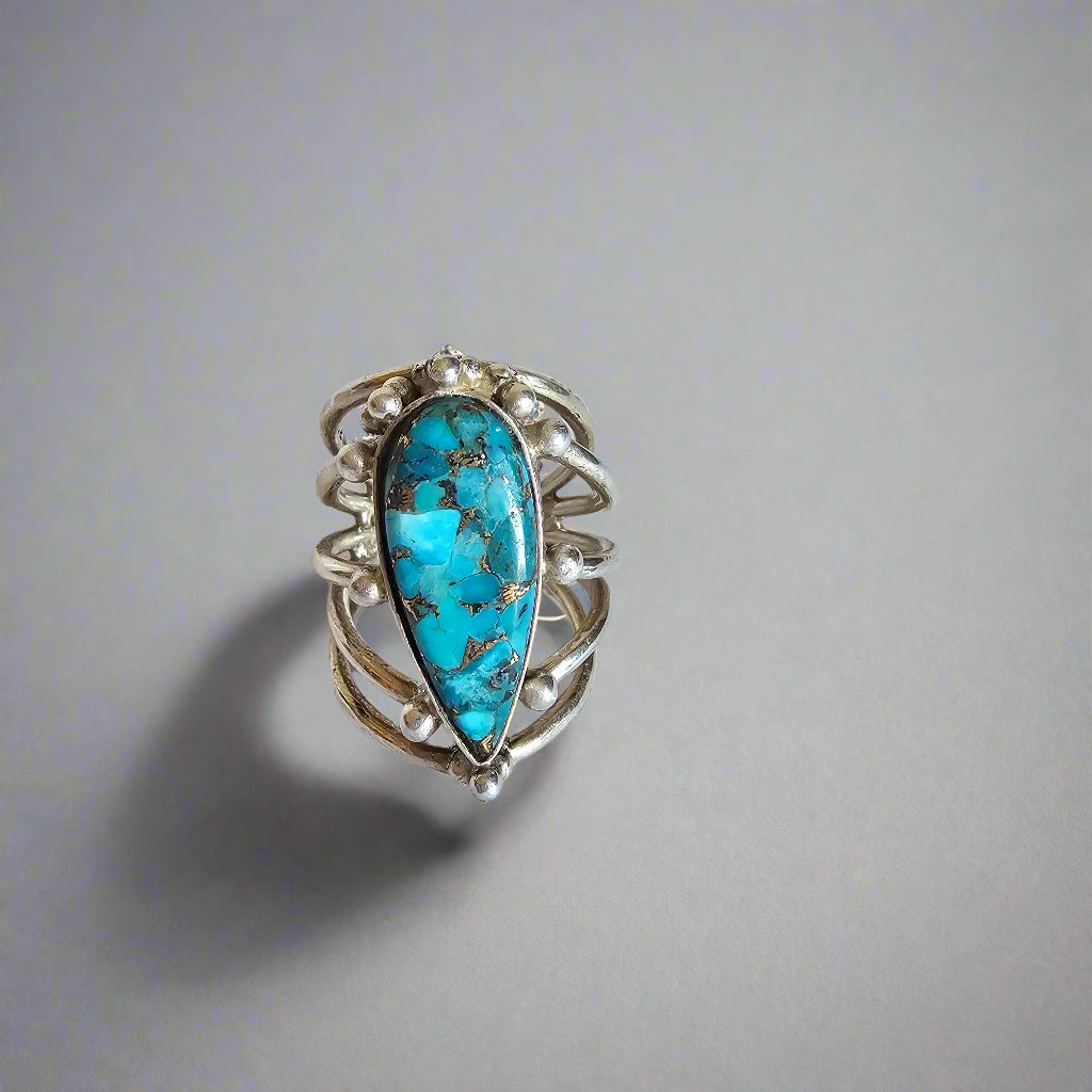 Silver ring with a turquoise stone on a white background