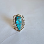 Silver ring with a turquoise stone on a white background