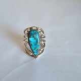 Silver ring with a turquoise stone on a white background