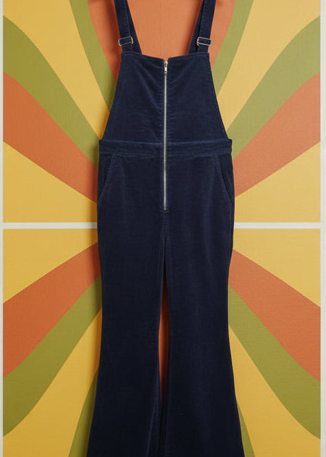 Navy blue overalls hanging against a colorful, abstract wall.