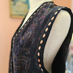 Close-up of a black sandal with intricate patterns on a blurred background