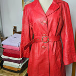 Front view of 1970s Stewart Hunt red leather trench coat with belt fastened, showcasing its tailored silhouette and vibrant color.