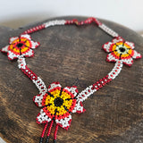 Beaded necklace with floral designs on a wooden surface