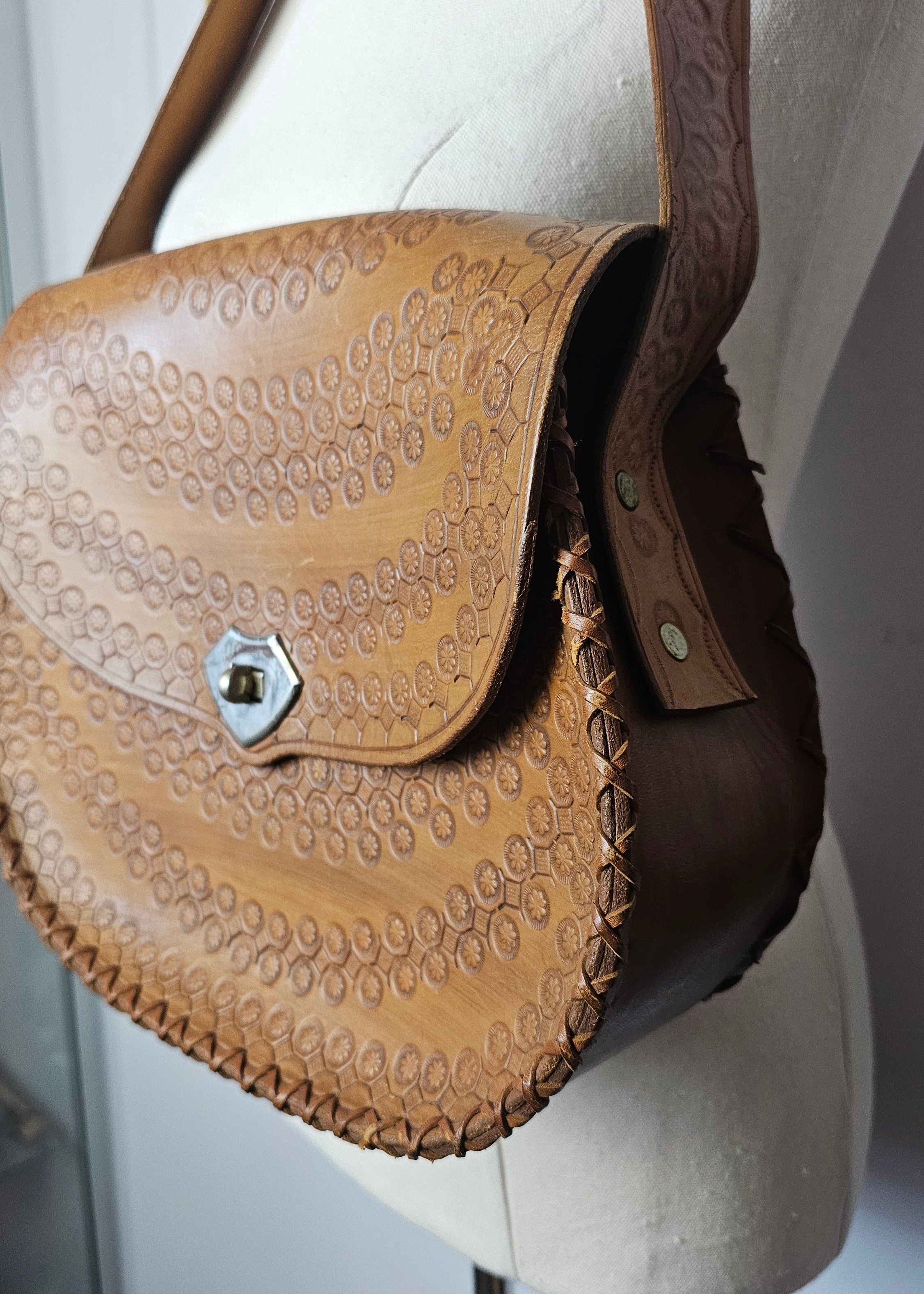 Brown leather saddle with intricate patterns on a vehicle ceiling
