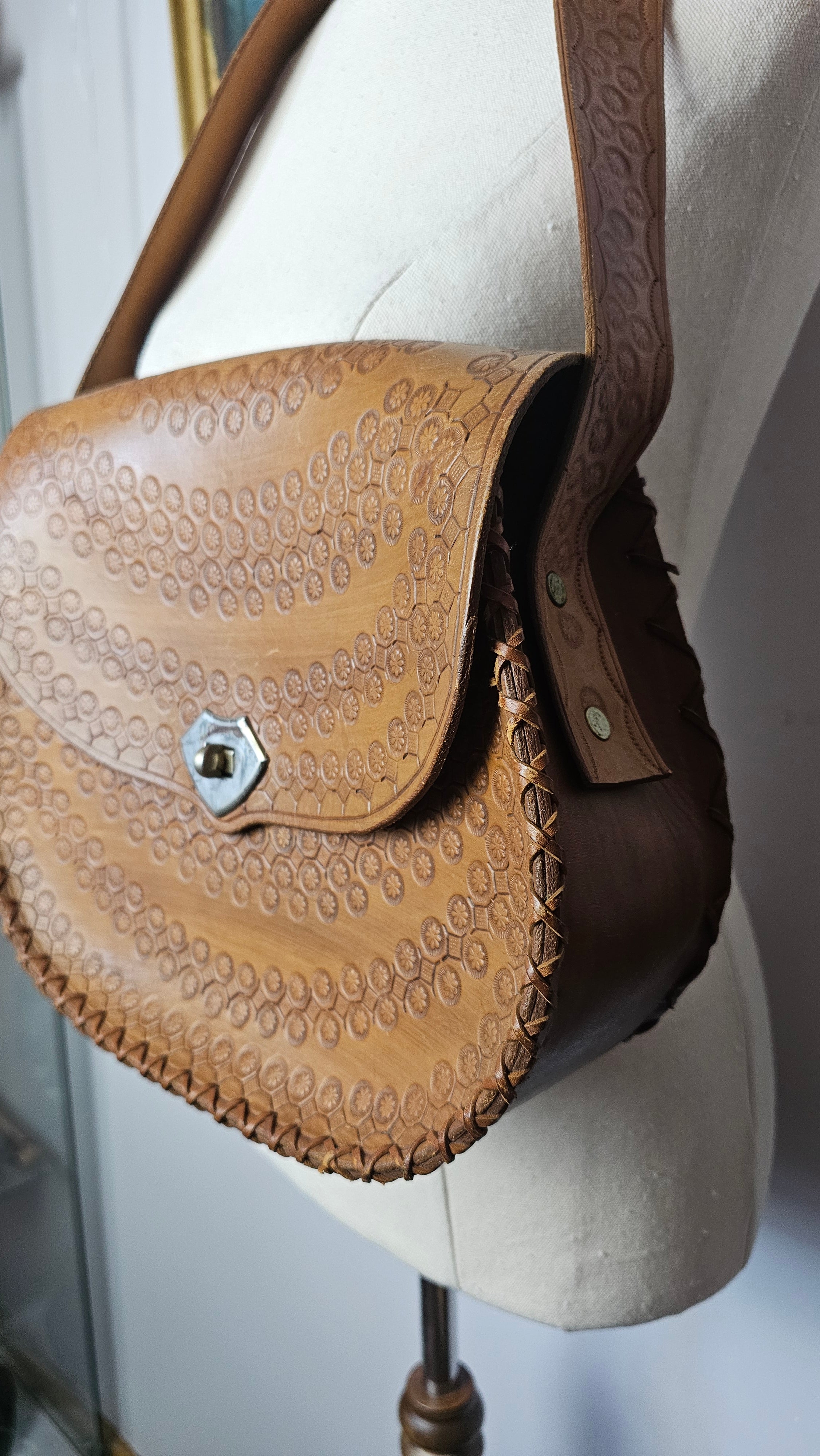 Brown leather saddle with intricate patterns on a vehicle ceiling