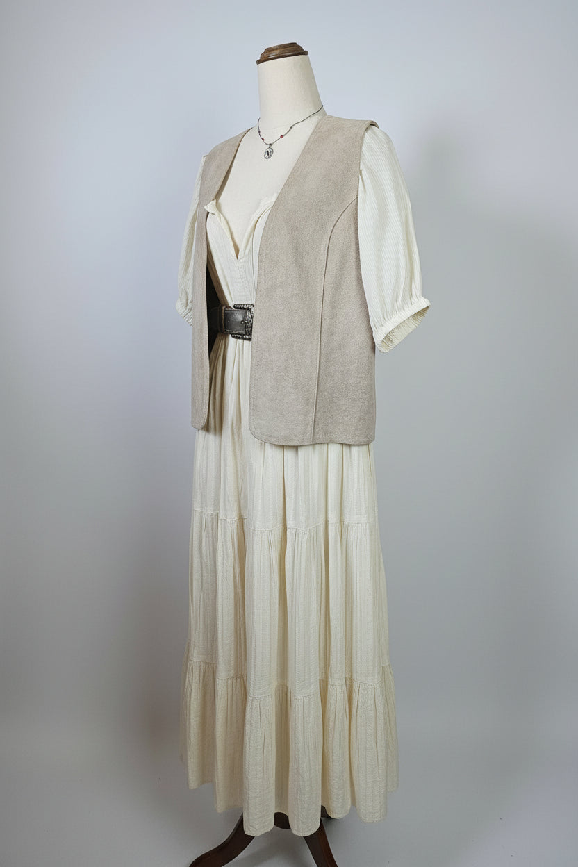 Mannequin wearing a beige suit with a white shirt and brown hat on a plain background