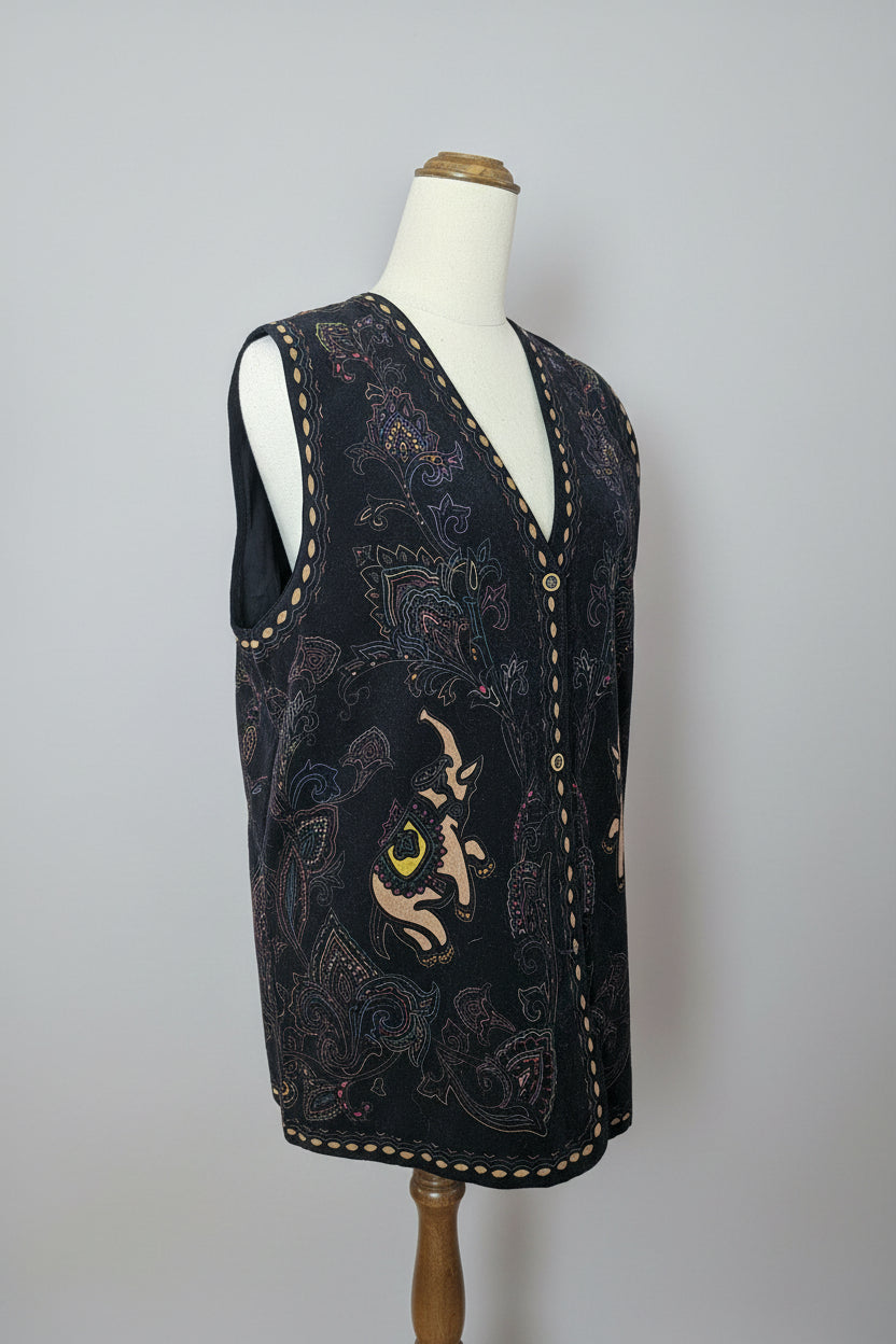 Embroidered black shoe with a cat design on a beige surface