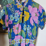 Floral fabric with pink, green, and yellow flowers on a blue background.