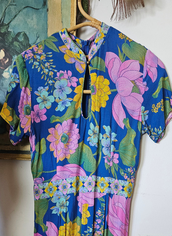 Floral fabric with pink, green, and yellow flowers on a blue background.