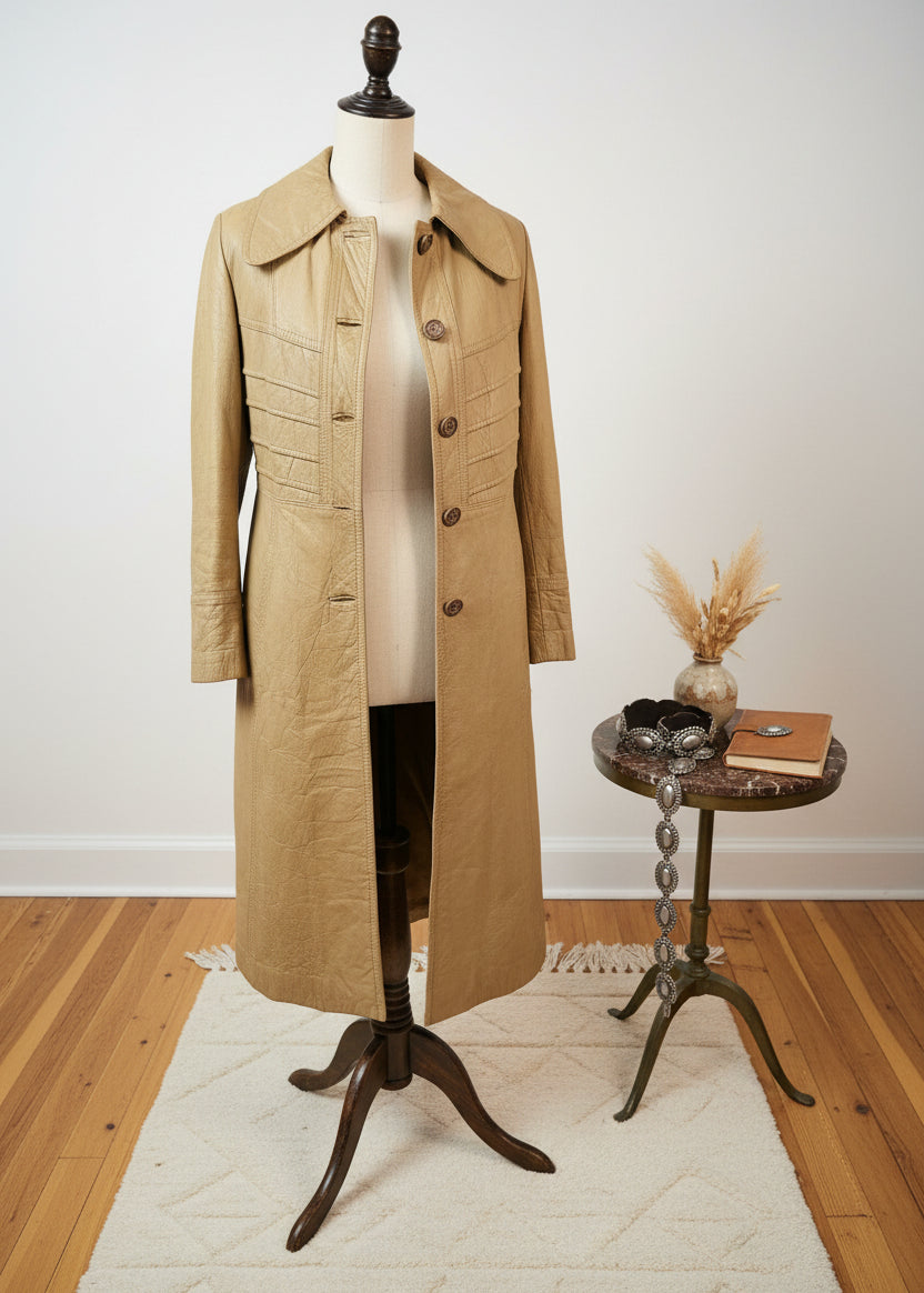 Beige trench coat on a textured white surface with wooden floor in the corner