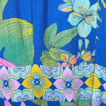 Colorful floral fabric with pink, blue, and green flowers on a blue background