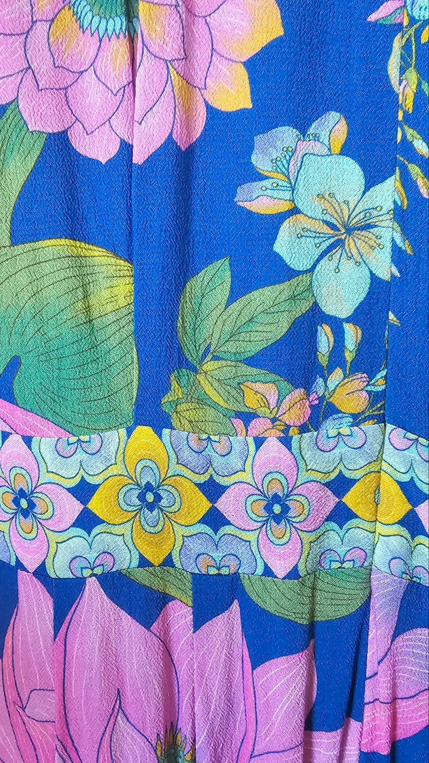 Colorful floral fabric with pink, blue, and green flowers on a blue background