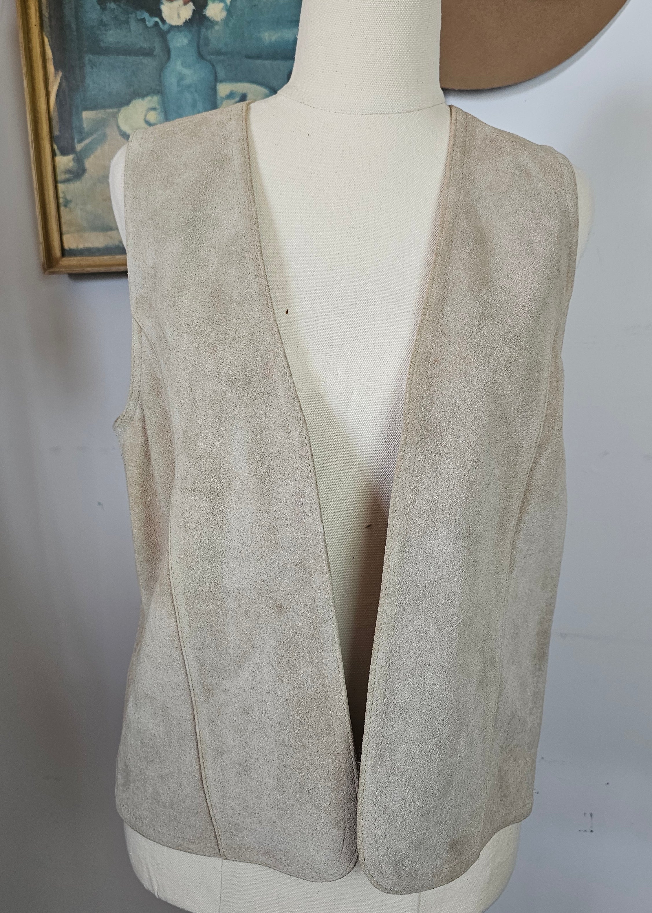 Mannequin wearing a beige trench coat against a plain background