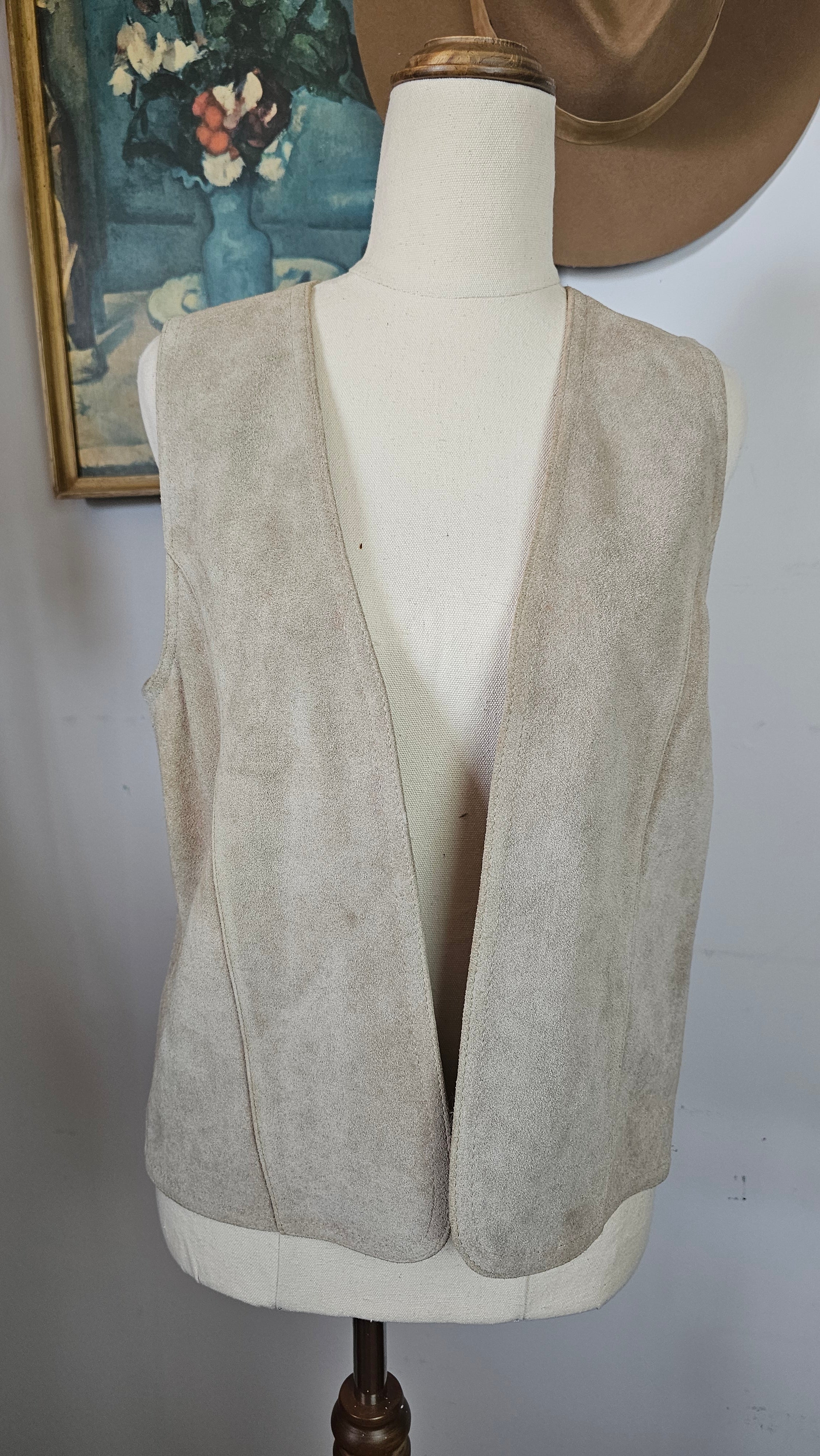 Mannequin wearing a beige trench coat against a plain background