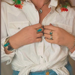 Person wearing a white shirt with floral embroidery and blue jeans, text 'The sweetest cactus western shirt'.