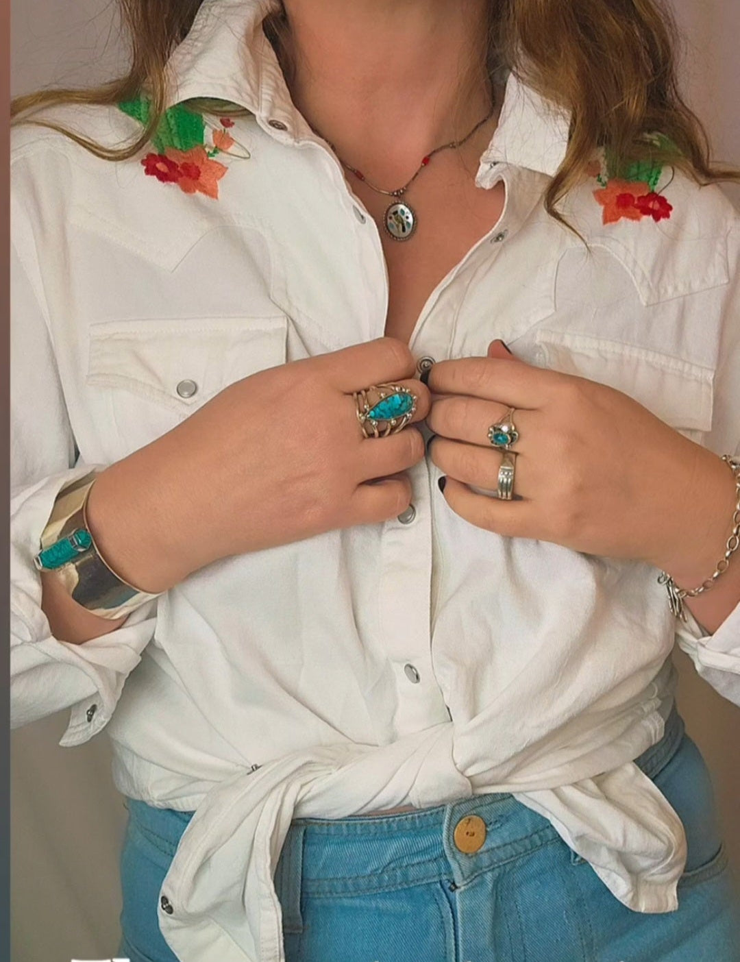 Person wearing a white shirt with floral embroidery and blue jeans, text 'The sweetest cactus western shirt'.