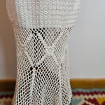 Close-up of a white fishnet glove on a neutral background