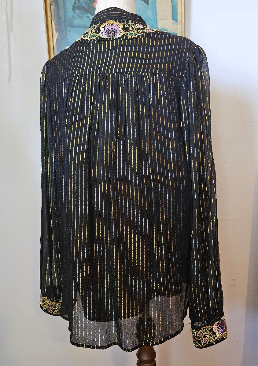 Traditional black garment with decorative elements on a white background