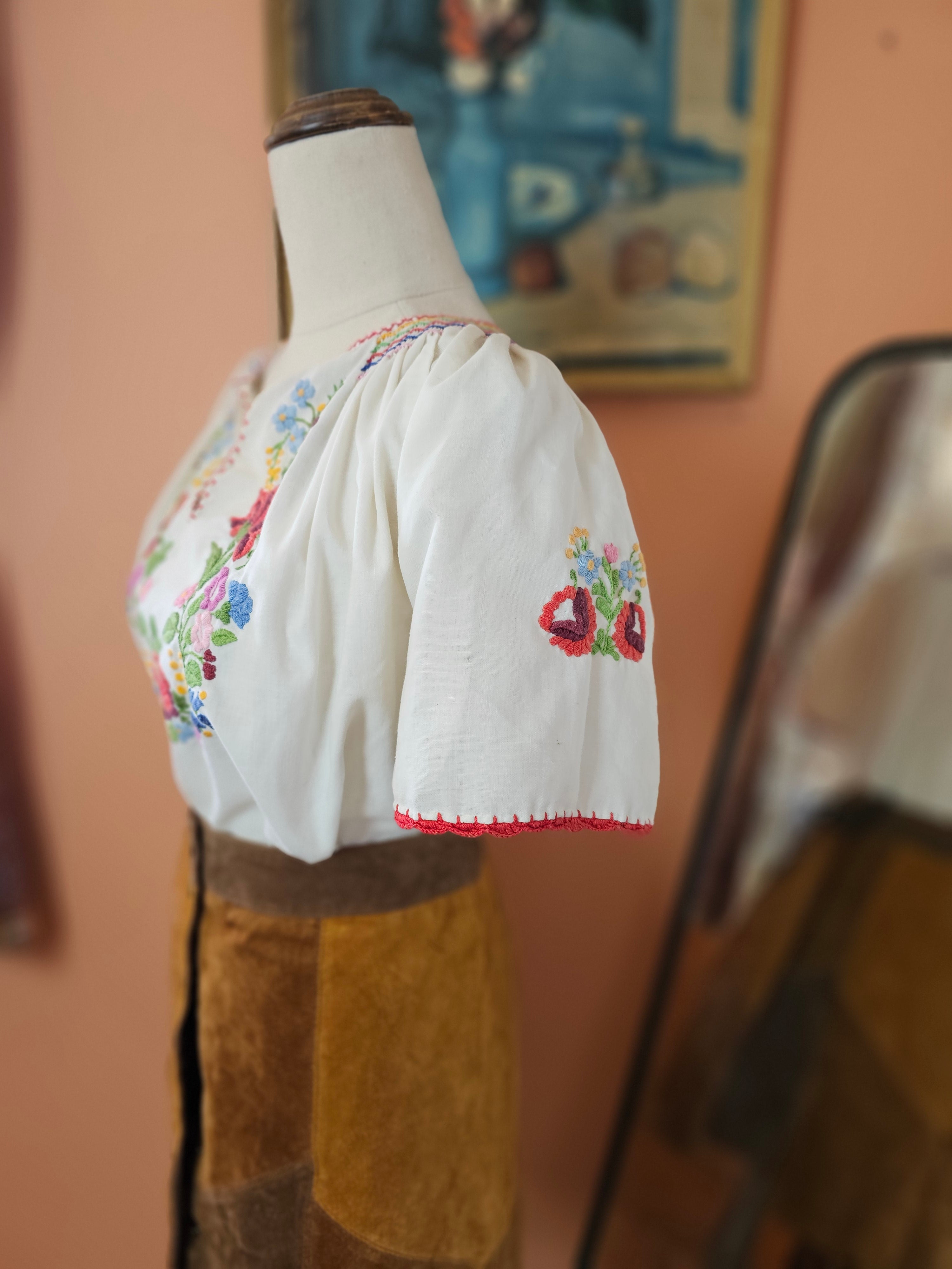 Embroidered white glove with colorful floral patterns on a blurred background