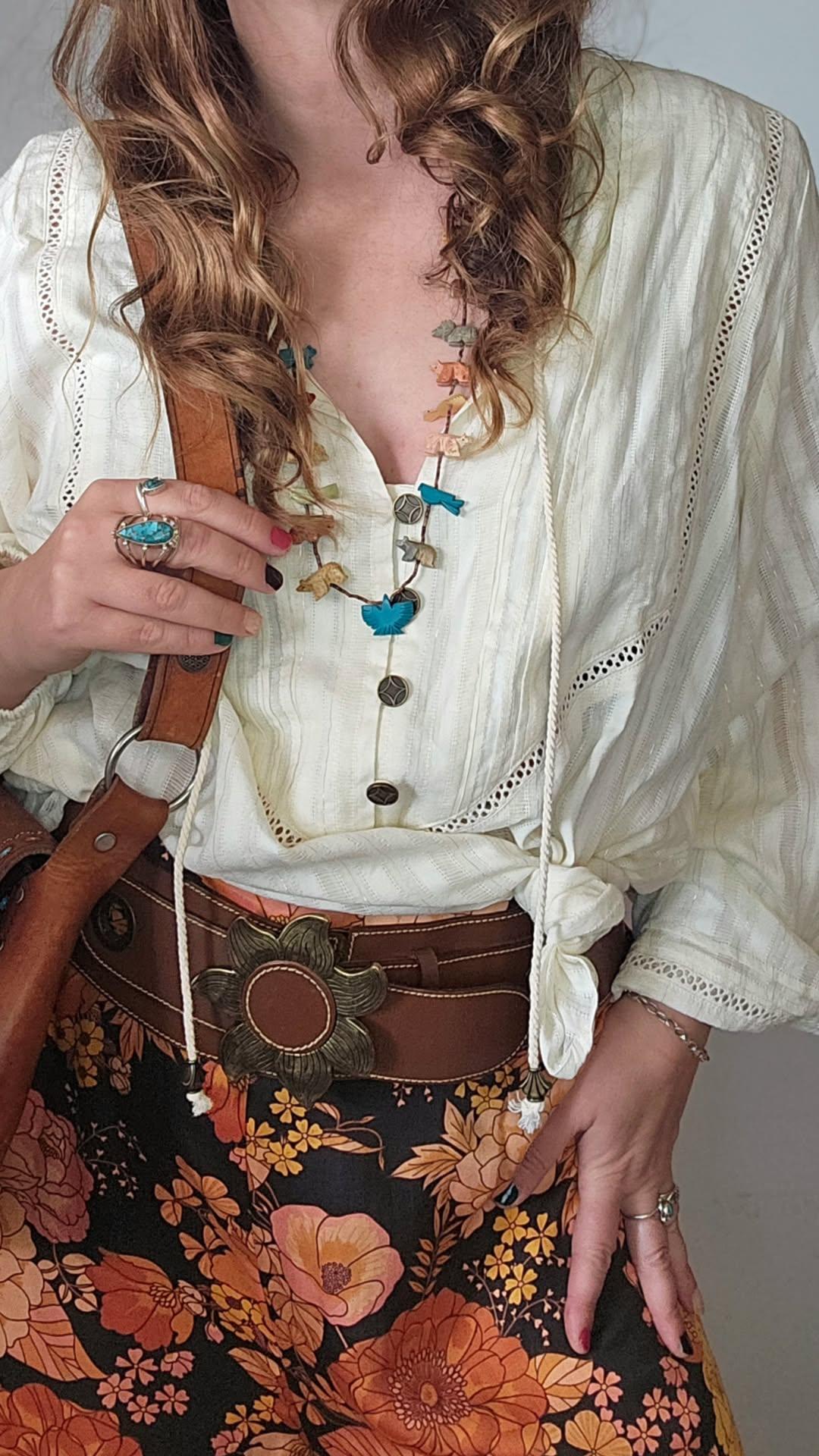 Person wearing a white blouse with floral skirt and accessories