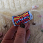 Hand holding a Dukes of Hazzard patch over a textured fabric background