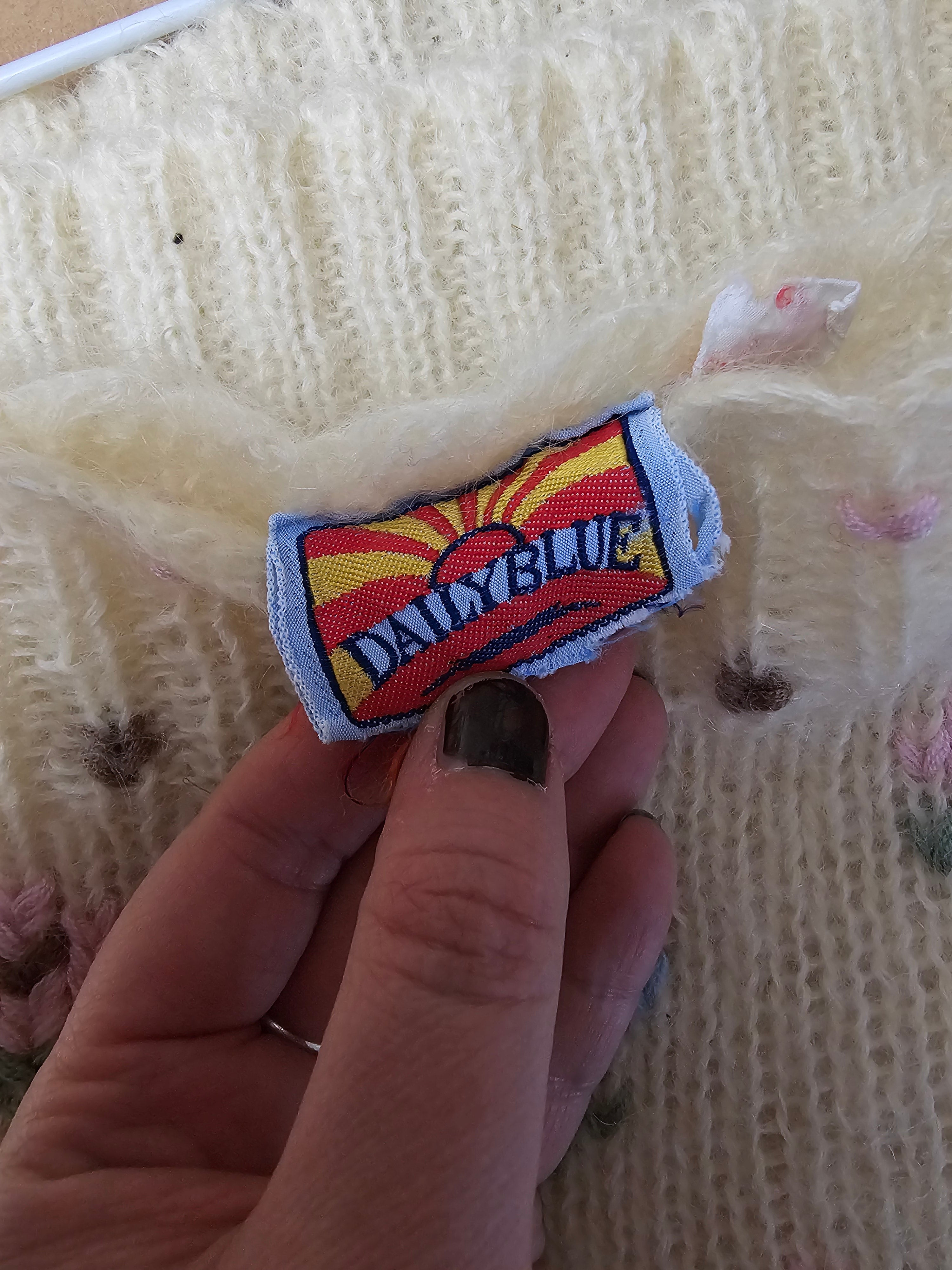 Hand holding a Dukes of Hazzard patch over a textured fabric background