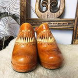 Front view of Vintage Wild Pair Tan Leather Mules – Size 37 showcasing 70s-style stitching and fringe leather accents on the upper.