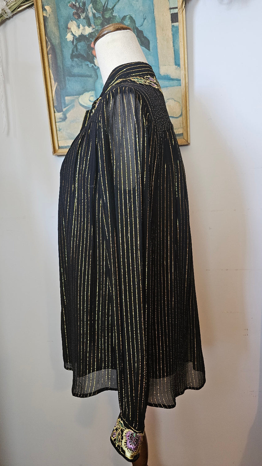 Black pleated skirt on a mannequin against a white background