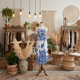 White dress with blue floral pattern on a mannequin against a white background