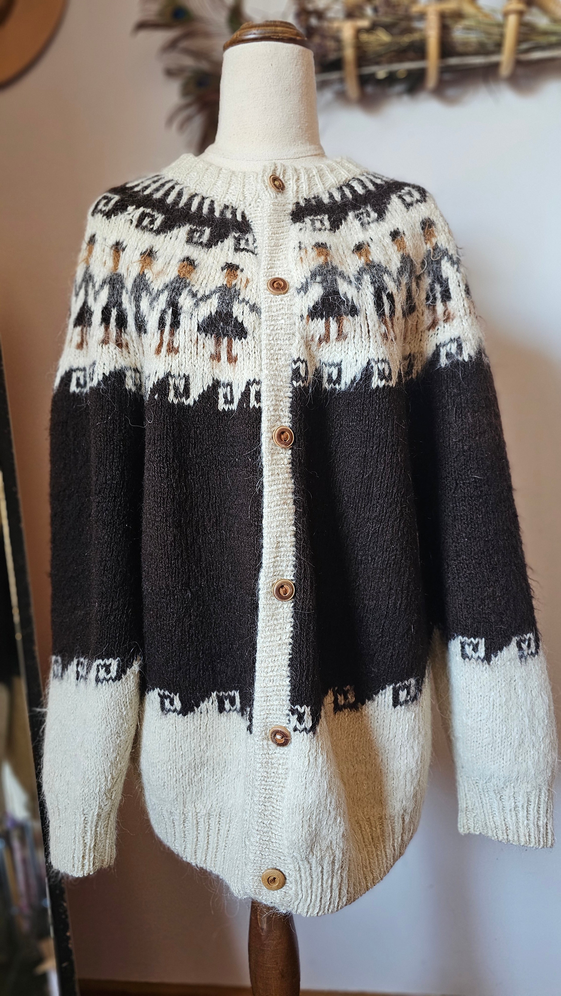 Knitted sweater with black and white pattern on a mannequin against a neutral background